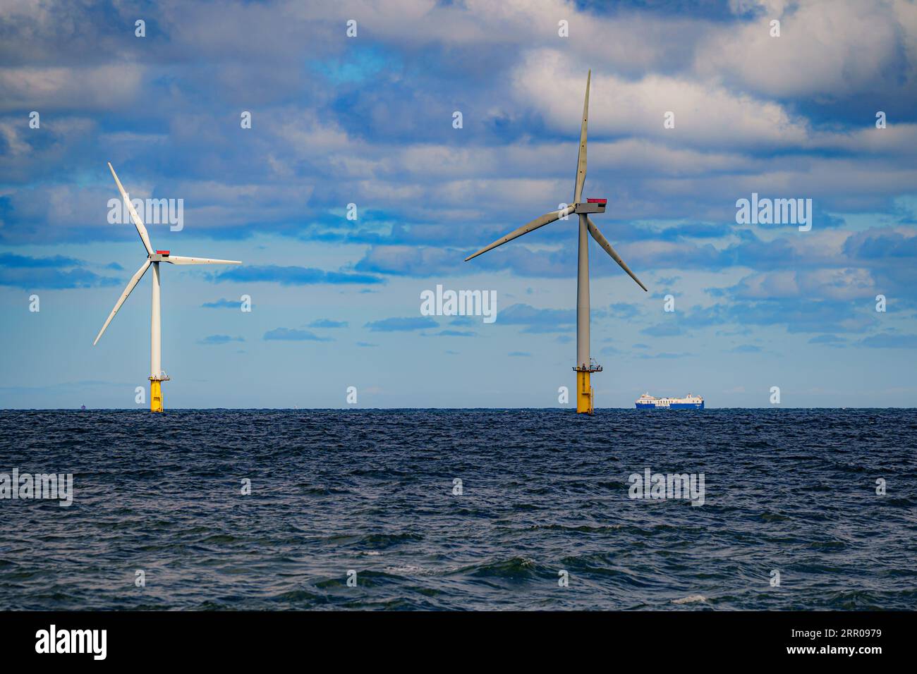 Photo de dossier datée du 26/07/2022 d'un navire passant devant des éoliennes à Gwynt y Mor de RWE. Des investissements du secteur privé d’une valeur pouvant atteindre 100 milliards de livres sterling sont nécessaires pour mener à bien des projets clés visant à préserver la sécurité énergétique du Royaume-Uni, selon l’industrie des énergies offshore. Banque D'Images