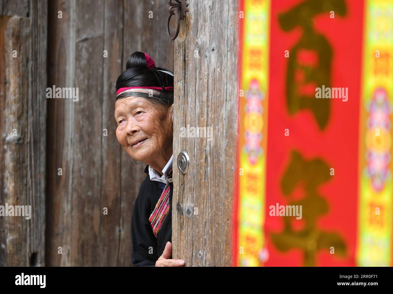 200812 -- NINGDE, 12 août 2020 -- Zhong Lianjiao est vu chez lui dans le village de Banyueli dans le comté de Xiapu, province du Fujian dans le sud-est de la Chine, le 5 août 2020. Il est courant de voir Zhong Lianjiao, une femme de 89 ans de l'ethnie she toujours en costumes traditionnels she, présenter les cultures de l'ethnie she aux touristes visitant l'ancien village Banyueli. Vivant dans le village depuis des décennies, Zhong a fait des efforts pour promouvoir le tourisme du village en présentant les cultures locales aux touristes. Banyueli est un village où les reliques culturelles et les coutumes folkloriques de l'ethnie she sont bien prese Banque D'Images