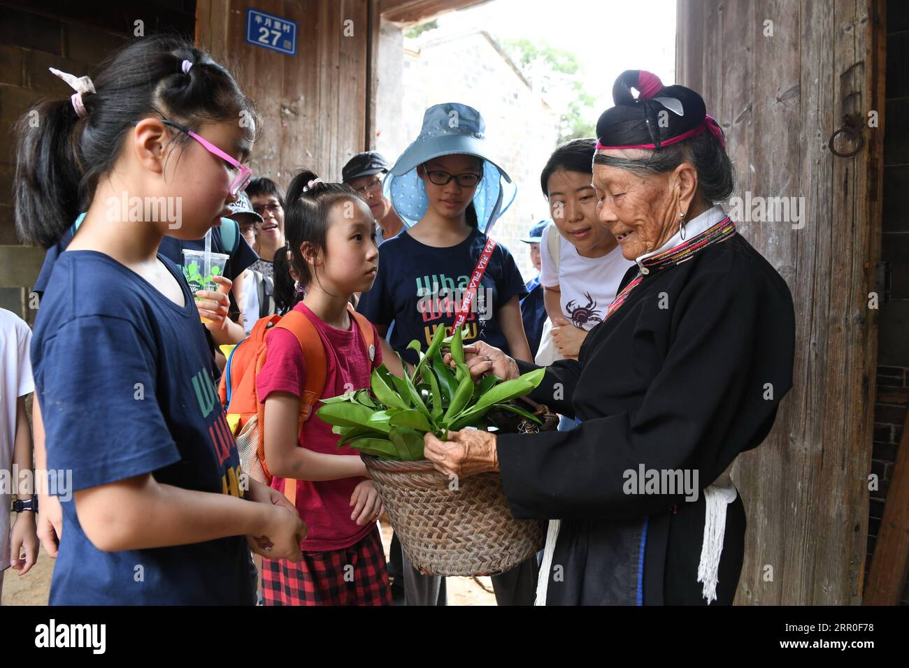 200812 -- NINGDE, 12 août 2020 -- Zhong Lianjiao 1st R présente une sorte de plante aux touristes au village de Banyueli dans le comté de Xiapu, province du Fujian du sud-est de la Chine, 5 août 2020. Il est courant de voir Zhong Lianjiao, une femme de 89 ans de l'ethnie she toujours en costumes traditionnels she, présenter les cultures de l'ethnie she aux touristes visitant l'ancien village Banyueli. Vivant dans le village depuis des décennies, Zhong a fait des efforts pour promouvoir le tourisme du village en présentant les cultures locales aux touristes. Banyueli est un village où les reliques culturelles et les coutumes folkloriques de SH Banque D'Images