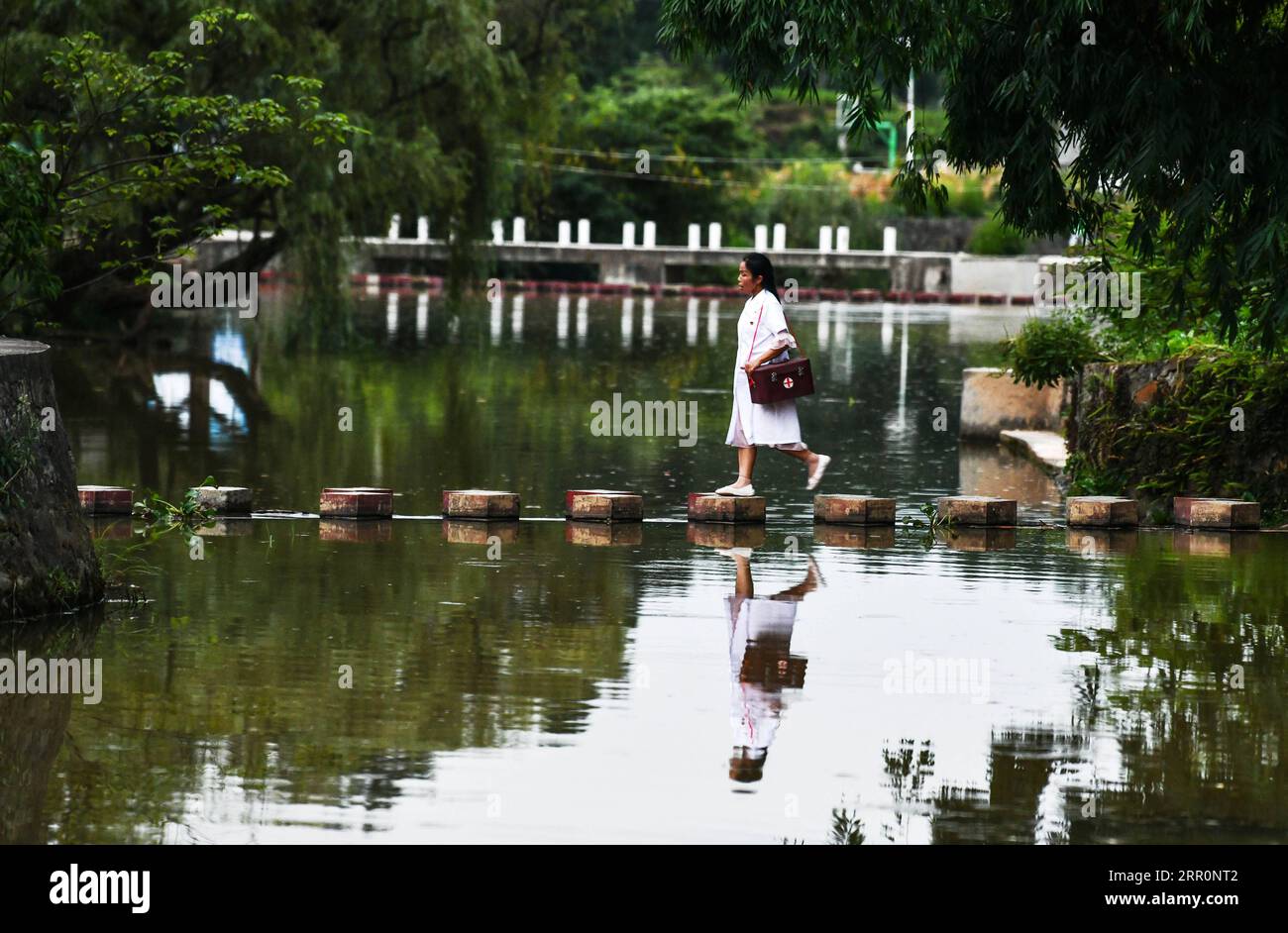 200822 -- PÉKIN, le 22 août 2020 -- Luo Mu est en route pour rendre visite à un patient dans le village de Cuiwei, dans le comté de Longli, préfecture autonome de Qiannan Buyi-Miao, province du Guizhou au sud-ouest de la Chine, le 18 août 2020. Luo Mu, 49 ans, médecin de l'ethnie Buyi, travaille dans le village de Cuiwei, dans le comté de Longli. Diplômée d'une école de médecine en 2004, elle est revenue au village en tant que médecin. Au cours des 16 dernières années, elle a traité environ 30 patients sur une base quotidienne et a revu les patients environ 1 000 fois par an. PHOTOS XINHUA DU JOUR YangxWenbin PUBLICATIONxNOTxINxCHN Banque D'Images