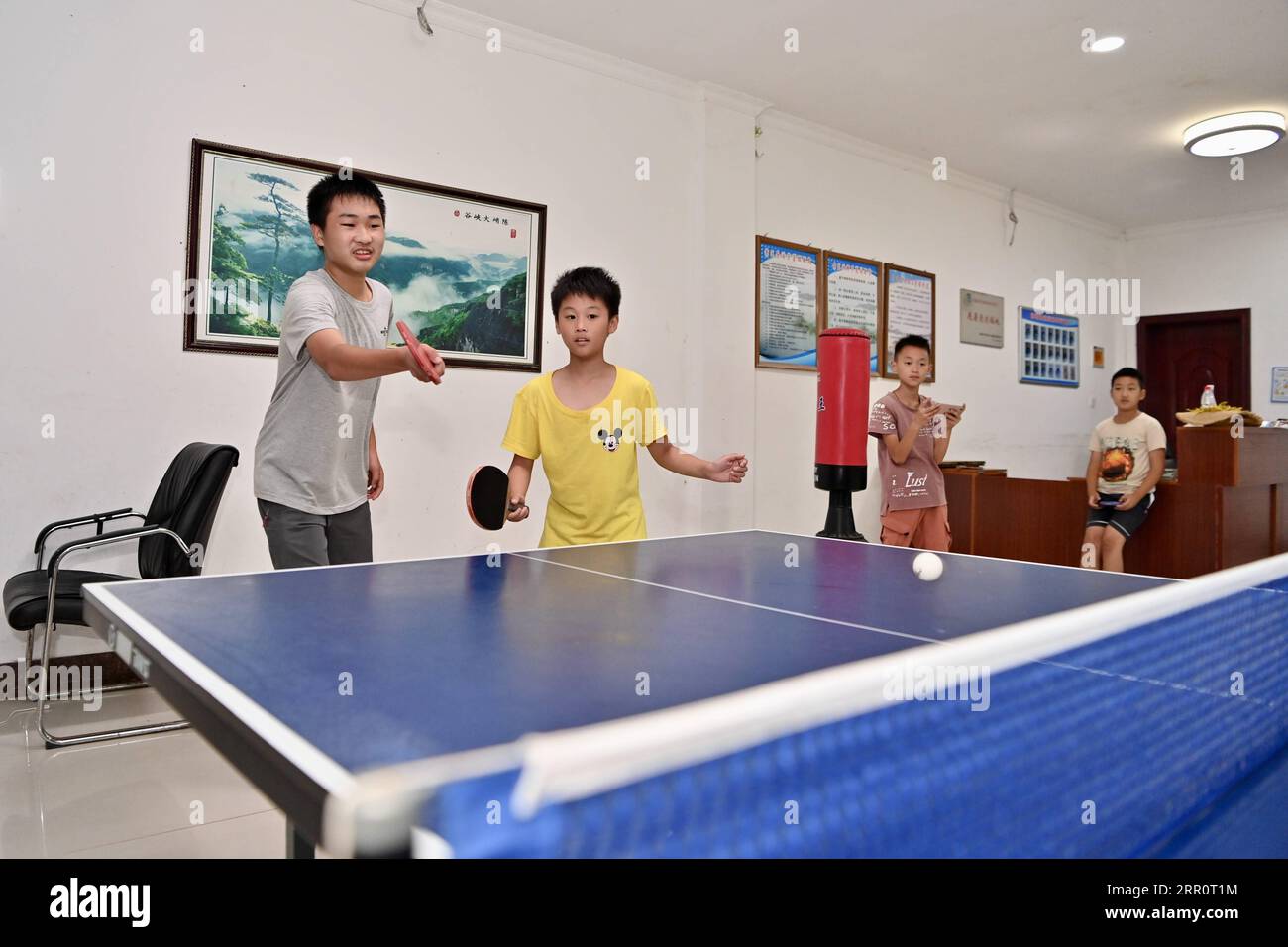 200825 -- FUZHOU, 25 août 2020 -- des enfants jouent au tennis de table dans un centre touristique du village de Chenqiao, comté de Zhouning, province du Fujian, dans le sud-est de la Chine, le 2 août 2020. Entouré de hautes montagnes et assis au sommet d'une falaise abrupte, Chenqiao est un village millénaire dans la province du Fujian, célèbre pour ses vallées, ses cascades et sa mer de nuages. Avec une altitude de 936 mètres et une température moyenne de 24 degrés Celsius en été, c'est aussi une station estivale préférée des touristes. Depuis le début de l'été, un nombre croissant de visiteurs sont attirés ici pour la randonnée, le camping et Banque D'Images