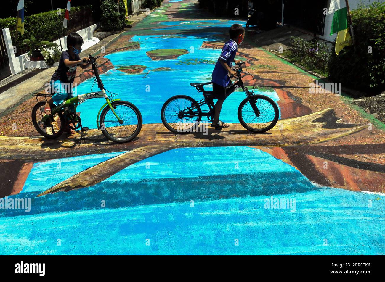 200826 -- JAKARTA, le 26 août 2020 -- des enfants font du vélo sur une allée piétonne avec des peintures tridimensionnelles à Jakarta, Indonésie, le 26 août 2020. Photo de /Xinhua INDONESIA-JAKARTA-PEINTURE 3D DasrilxRoszandi PUBLICATIONxNOTxINxCHN Banque D'Images