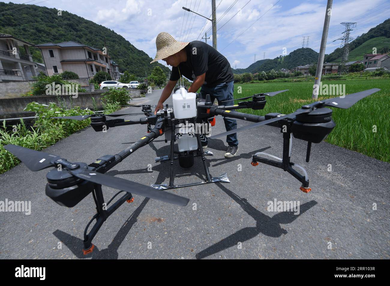 200830 -- HANGZHOU, 30 août 2020 -- Tang Baiqing ajuste un drone de pulvérisation de pesticides près d'un champ dans le village de Xintai du district de Yuhang à Hangzhou, dans la province du Zhejiang de l'est de la Chine, le 23 juillet 2020. Tang Baiqing retourne dans sa ville natale après avoir obtenu son diplôme universitaire en 2014, pour démarrer son entreprise agricole en plantant du riz, du blé, du cole et d'autres cultures dans sa ferme. Jusqu'à présent, sa ferme a contracté des terres de plus de 900 mu environ 60 hectares dans plusieurs villages, avec un centre de séchage de 1 300 mètres carrés et un centre d'élevage de semis de 1 200 mètres carrés. La ferme a également investi plus de 4,5 Banque D'Images