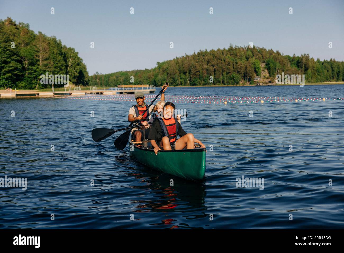 Fille souriante kayak avec conseiller sur le lac au camp d'été Banque D'Images