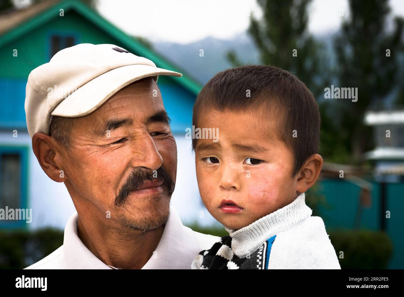 Homme avec enfant sur le bras, portrait, Orlinoe, Kirghizistan Banque D'Images