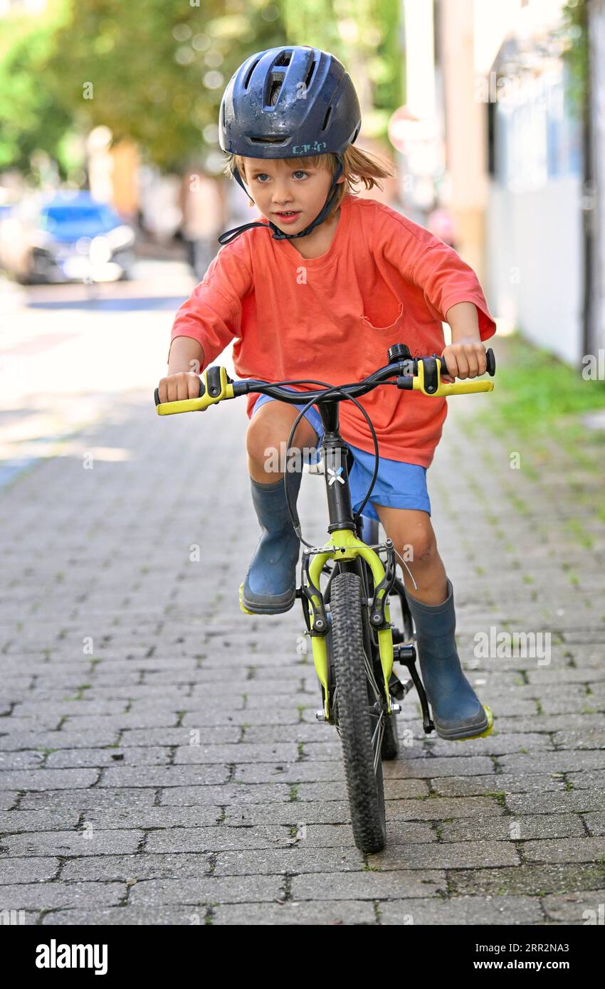 Petit garçon, blond, 5 ans, vélo pour enfants, casque, environnement urbain, Stuttgart, Baden-Wuerttemberg, Allemagne Banque D'Images