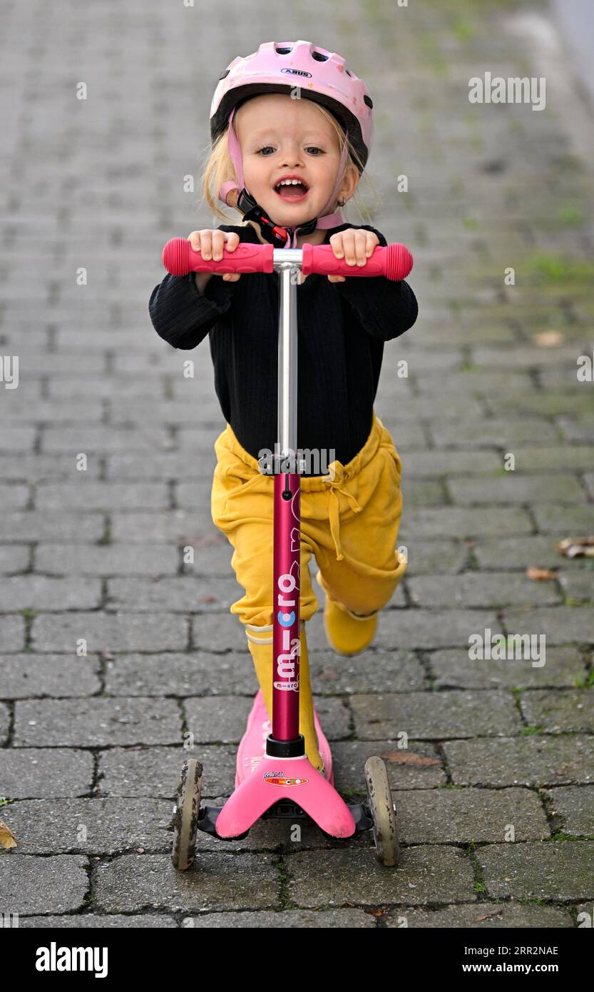 Petite fille, blonde, 2 ans, trottinette, casque, environnement urbain, Stuttgart, Baden-Wuerttemberg, Allemagne Banque D'Images