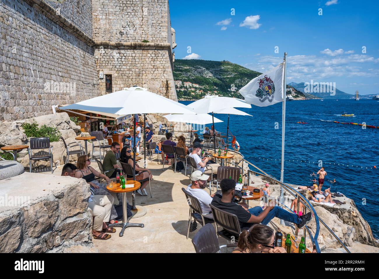 Touristes sur un café en terrasse à l'extérieur des murs de la ville dans la vieille ville fortifiée de Dubrovnik sur la côte dalmate de la Croatie Banque D'Images