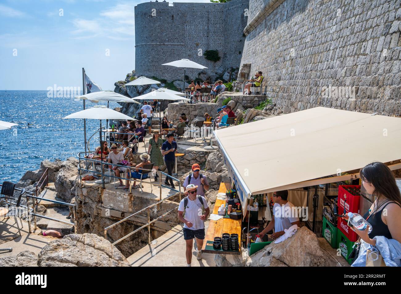 Touristes sur un café en terrasse à l'extérieur des murs de la ville dans la vieille ville fortifiée de Dubrovnik sur la côte dalmate de la Croatie Banque D'Images