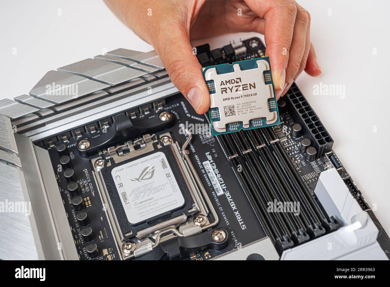 Installation manuelle du processeur AMD Ryzen 9 7950X3D dans la carte mère Photo Stock Alamy