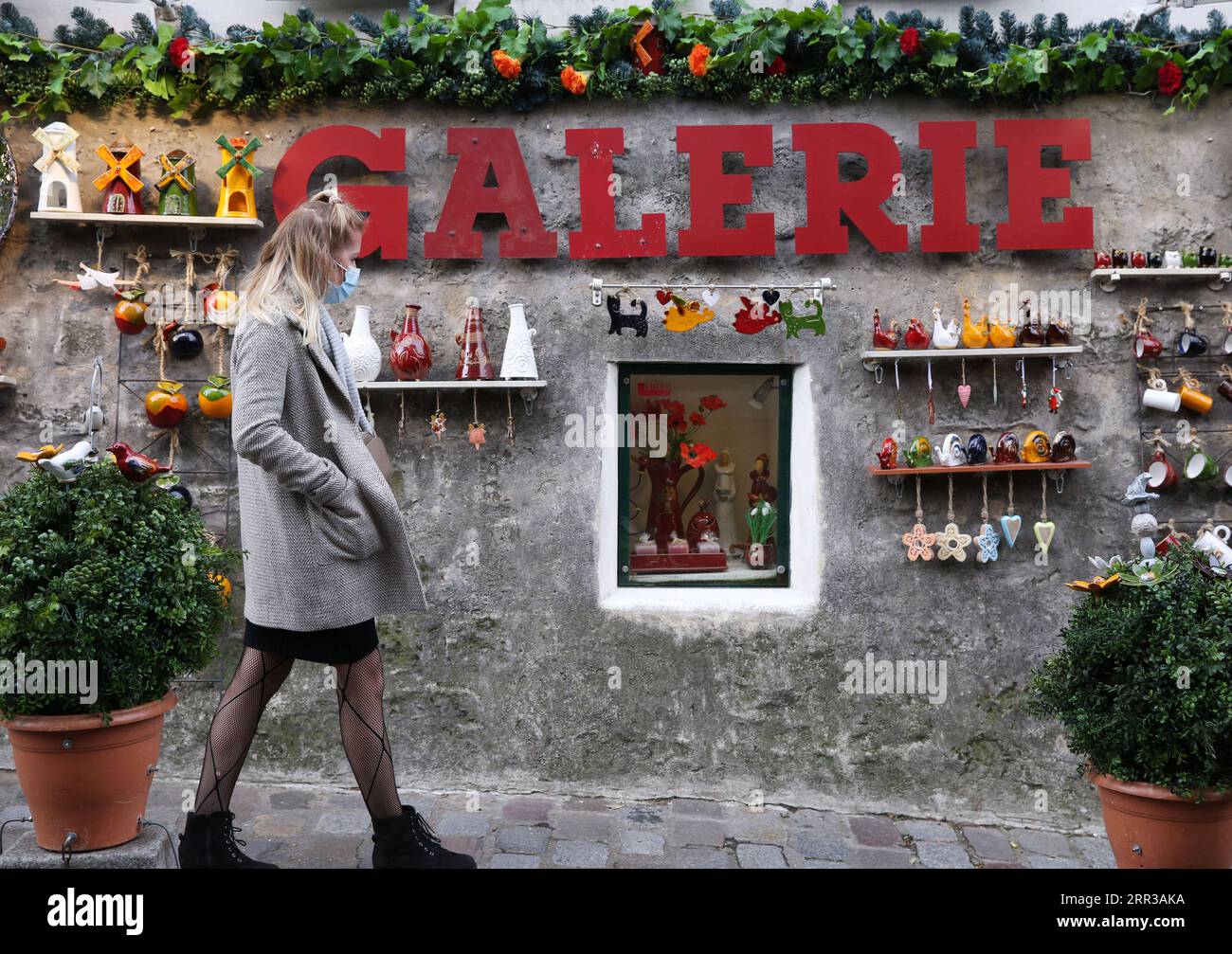 201029 -- PARIS, le 29 octobre 2020 -- Une femme passe devant une boutique de porcelaine à Montmartre, Paris, France, le 28 octobre 2020. La France entrera en confinement national à partir de vendredi pour endiguer la deuxième vague de l’épidémie de coronavirus, a annoncé mercredi soir le président Emmanuel Macron. La France a enregistré mercredi 36 437 nouvelles infections à COVID-19, 3 020 de plus que le nombre enregistré au cours des 24 heures précédentes. Le nombre cumulé de cas de coronavirus a grimpé à 1 235 132, dont 35 785 décès, en hausse de 244 en une journée, ont montré les chiffres publiés par l’Agence de la santé publique. FRANCE-PARIS-LOCKDOWN Banque D'Images