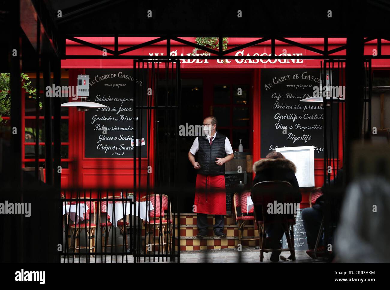 201029 -- PARIS, le 29 octobre 2020 -- Un serveur attend des clients devant un restaurant de la place du Tertre à Montmartre, Paris, France, le 28 octobre 2020. La France entrera en confinement national à partir de vendredi pour endiguer la deuxième vague de l’épidémie de coronavirus, a annoncé mercredi soir le président Emmanuel Macron. La France a enregistré mercredi 36 437 nouvelles infections à COVID-19, 3 020 de plus que le nombre enregistré au cours des 24 heures précédentes. Le nombre cumulé de cas de coronavirus a grimpé à 1 235 132, dont 35 785 décès, en hausse de 244 en une journée, chiffres publiés par Santé publique Agen Banque D'Images