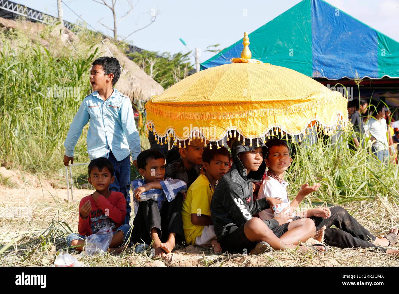 201030 -- KANDAL, le 30 octobre 2020 -- des enfants se rassemblent sous un parapluie pour assister à des courses de bateaux lors de la fête annuelle de l'eau près d'un lac dans le district de Lavea EM, province de Kandal, à environ 30 kilomètres à l'est de la capitale cambodgienne Phnom Penh, le 30 octobre 2020. Photo de /Xinhua CAMBODIA-KANDAL-WATER FESTIVAL-CELEBRATION Sovannara PUBLICATIONxNOTxINxCHN Banque D'Images