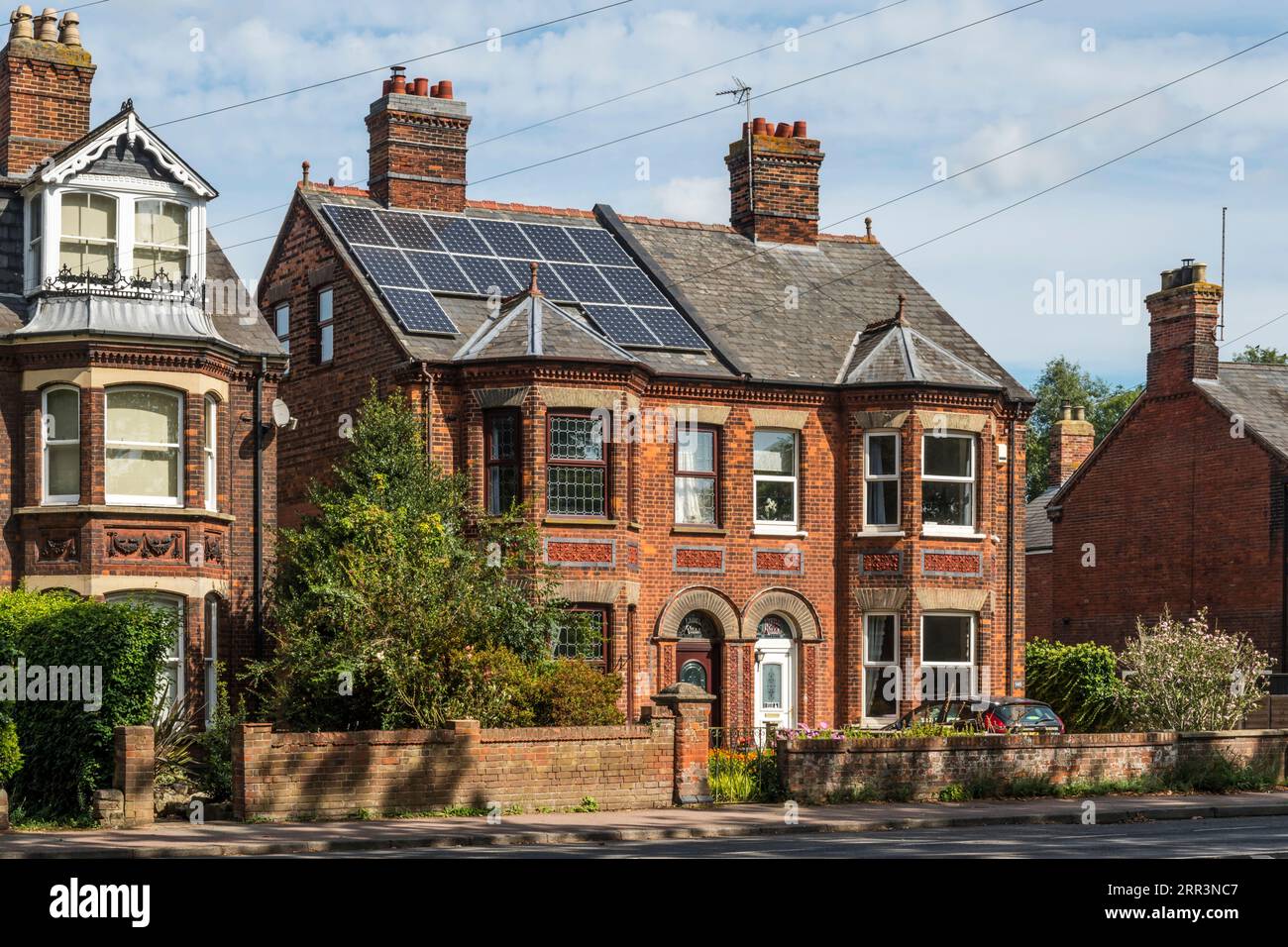 Grandes maisons jumelées. Une avec panneaux solaires sur le toit. Banque D'Images