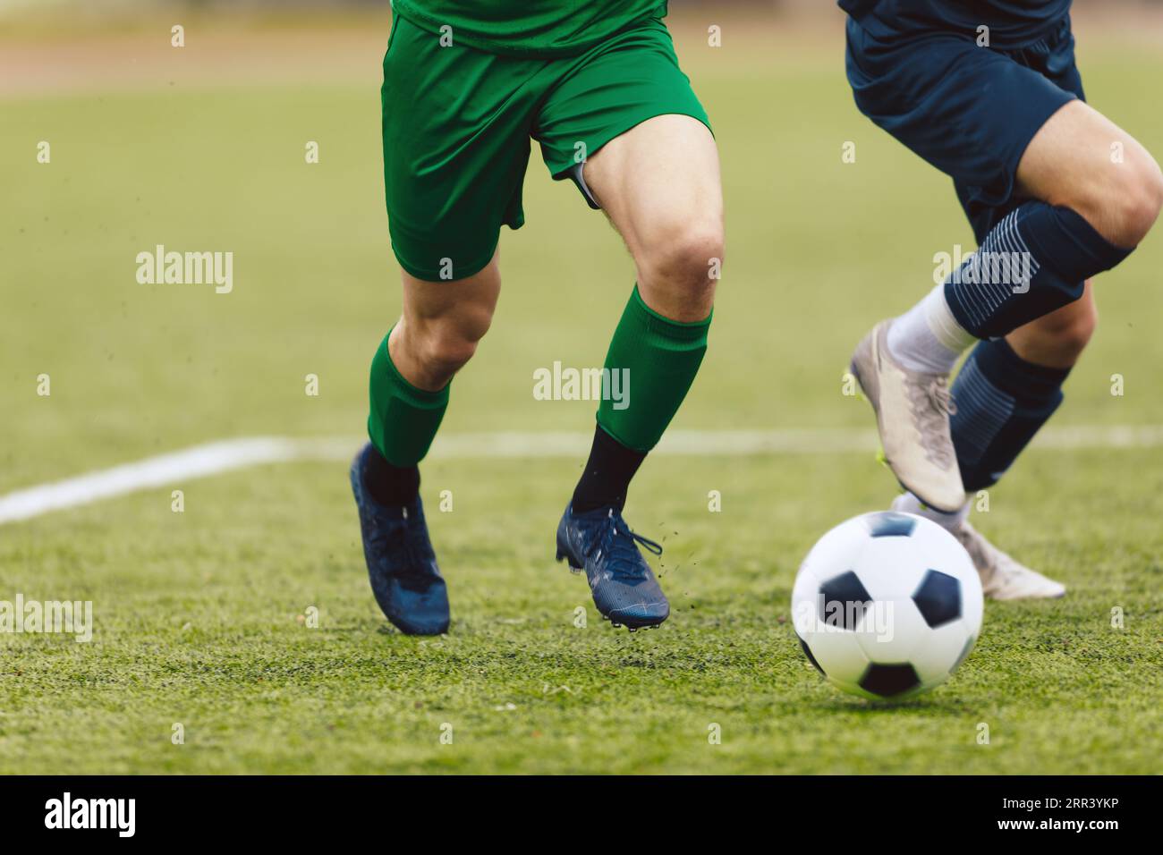 Compétition de football pour adultes. Joueur de football de football dribble un ballon et frapper un ballon pendant le match dans le stade. Footballeurs en action sur le tourname Banque D'Images