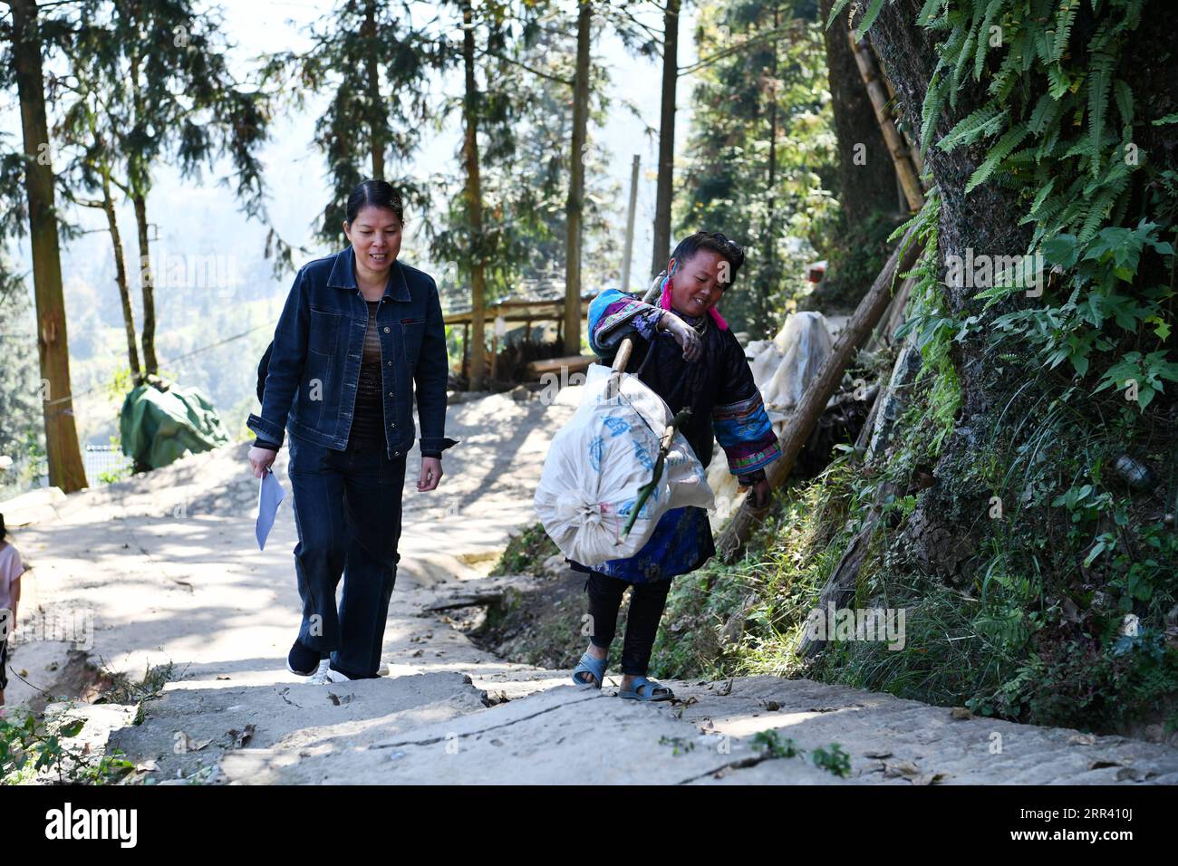 201116 -- GUIYANG, 16 novembre 2020 -- Liu Ying L discute avec un villageois en route pour rendre visite à une famille pauvre enregistrée dans le village de Dongqin, comté de Congjiang, province du Guizhou, dans le sud-ouest de la Chine, le 11 novembre 2020. Situé dans la région de la montagne Yueliang, le comté de Congjiang est l'un des neuf comtés du Guizhou qui luttent encore contre la pauvreté. Après avoir obtenu son diplôme universitaire, He Changle, rejoint sa mère Liu Ying, devient assistant de lutte contre la pauvreté dans le village de Dongqin du comté de Congjiang à la fin de 2019. Dans leur travail, ils parviennent à résoudre les difficultés rencontrées par les villageois locaux, y compris la rénovation de dil Banque D'Images