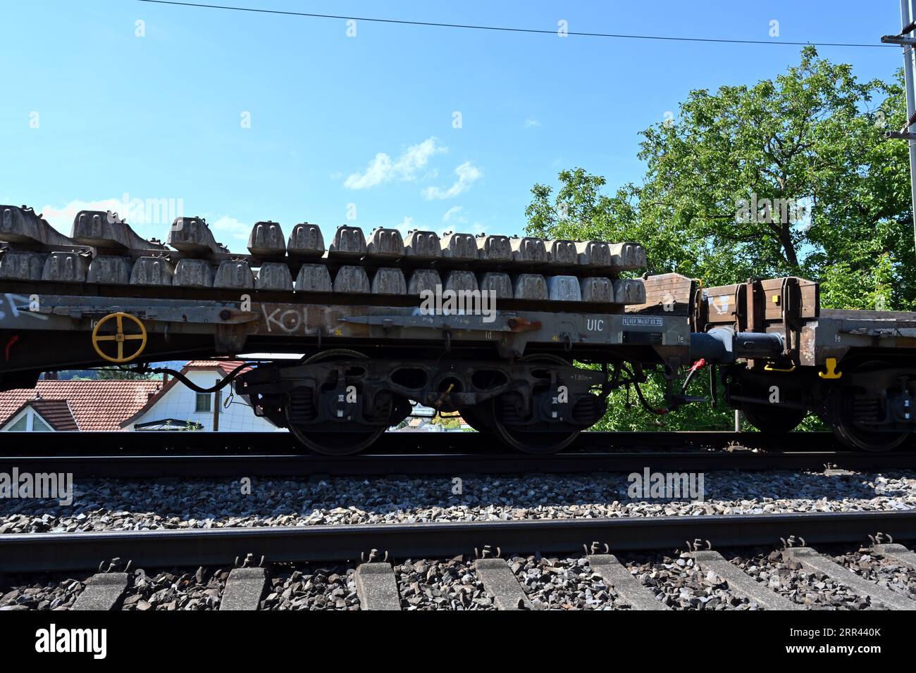 Un wagon de chemin de fer chargé de traverses en béton se dresse sur les rails menant à la gare d’Urdorf en Suisse. Banque D'Images