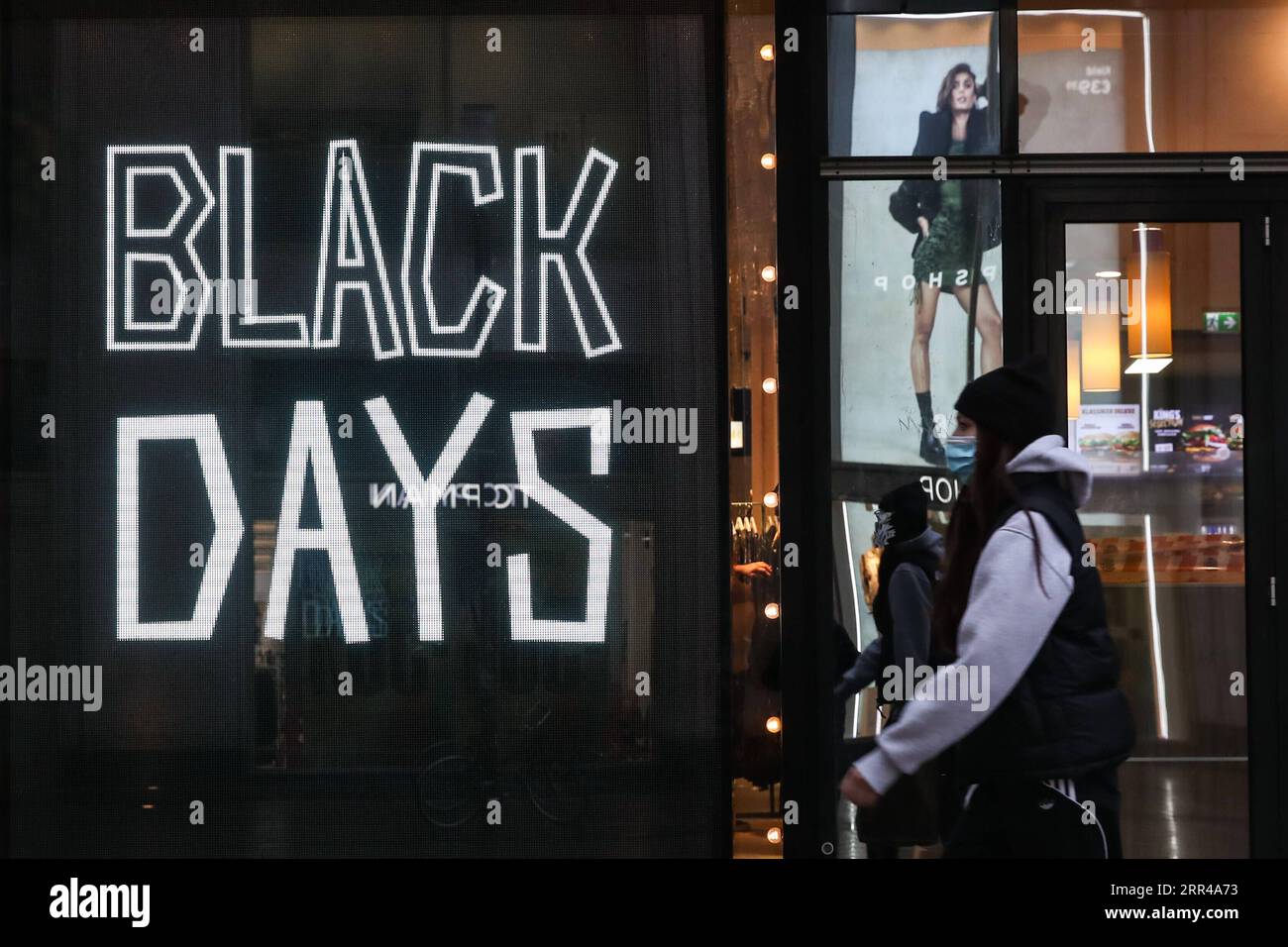 201126 -- BERLIN, le 26 novembre 2020 -- Un piéton passe devant un écran annonçant le Black Friday devant un magasin à Berlin, capitale de l'Allemagne, le 26 novembre 2020. À la suite de la hausse des taux d’infection par le COVID-19 en Allemagne, les gouvernements fédéral et des États ont décidé le 25 novembre que le confinement partiel, y compris la fermeture des restaurants, des bars, des théâtres et des installations de loisirs, serait prolongé jusqu’au 20 décembre. Photo de Shan Yuqi/Xinhua ALLEMAGNE-BERLIN-COVID-19-EXTENSION PARTIELLE DU CONFINEMENT DanxYuqi PUBLICATIONxNOTxINxCHN Banque D'Images