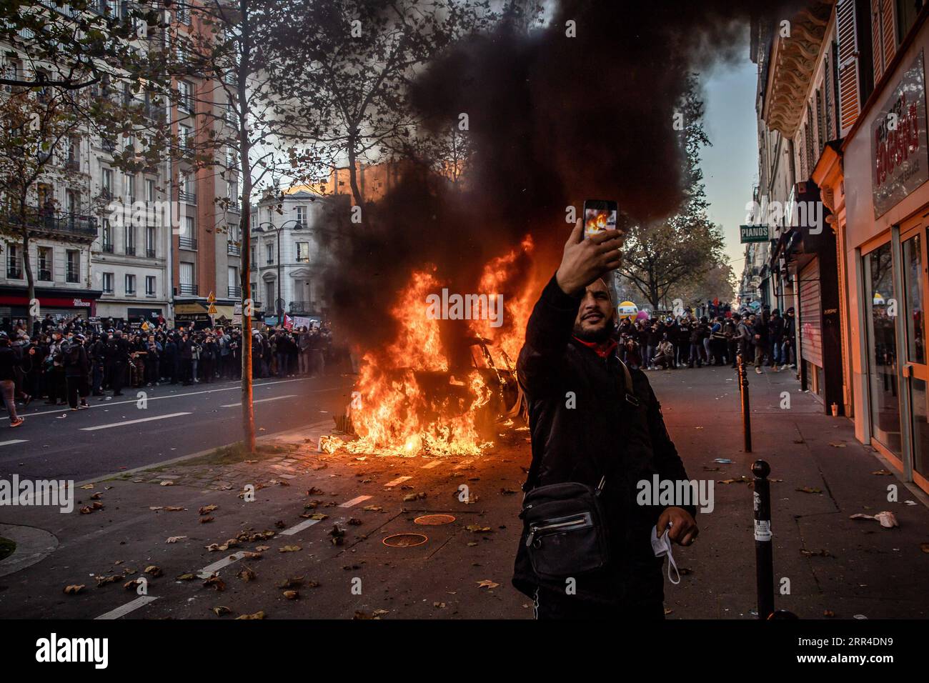201201 -- PÉKIN, 1 décembre 2020 -- Un homme prend un selfie devant une voiture éclairée par des manifestants lors d'affrontements avec la police lors d'une manifestation à Paris, France, le 28 novembre 2020. Des violences ont éclaté entre la police et les manifestants à Paris et dans d'autres villes françaises lors des manifestations de samedi contre un projet de loi controversé qui restreint la publication d'images de police. Photo de /Xinhua XINHUA PHOTOS DU JOUR AurelienxMorisard PUBLICATIONxNOTxINxCHN Banque D'Images