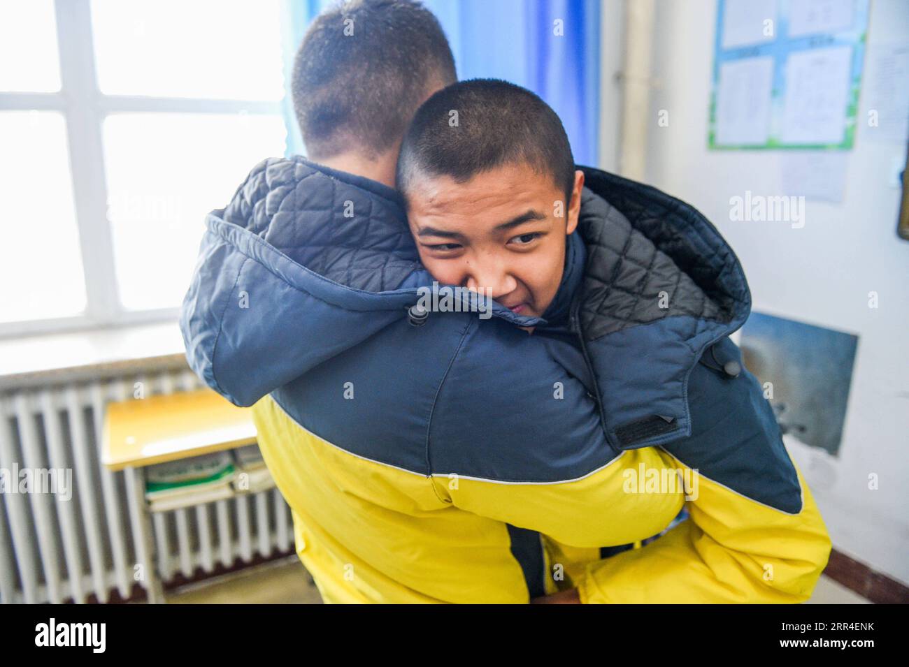 201202 -- CHIFENG, 2 décembre 2020 -- Sun Simiao tient Wang Aoran et se prépare à l'aider à quitter l'école à Chifeng City, dans la région autonome de Mongolie intérieure du nord de la Chine, le 25 novembre 2020. Wang Aoran, 15 ans, a été handicapé en action par une anomalie de créatine kinase depuis qu'il était enfant. Alors qu'il était en deuxième année de l'école primaire, il a reçu l'aide de son camarade de classe Sun Simiao, qui a volontairement commencé à le transporter de la porte de l'école à sa classe. Il l'aide depuis. Les deux sont devenus inséparables meilleurs amis. Ils sont allés au même collège, tous les deux dans la même classe, et ils sont même devenus Banque D'Images