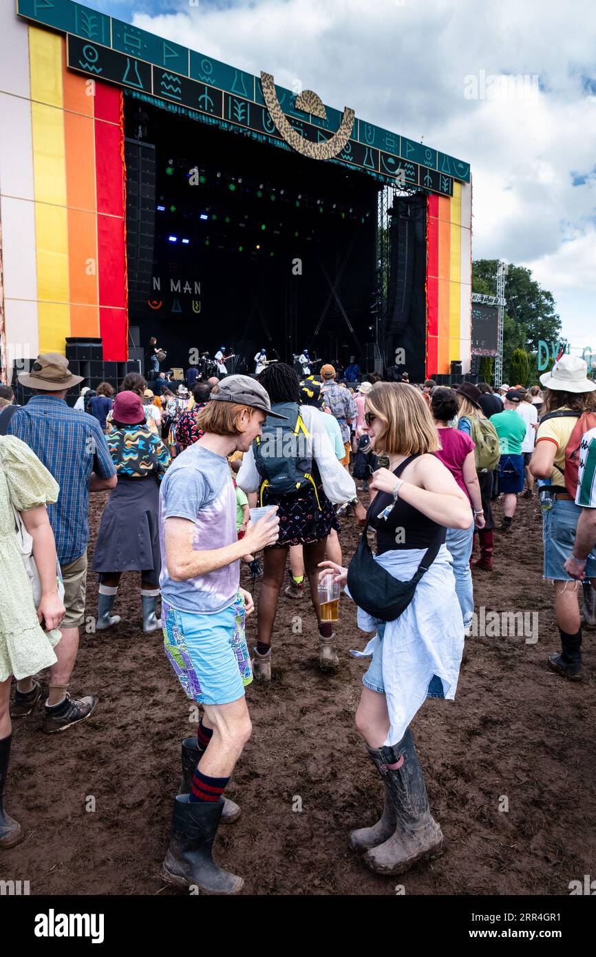 Un jeune couple dansant avec des bières dans la boue à la Mountain Stage au Green Man Festival, Brecon, pays de Galles, Royaume-Uni, 2023. Photo : Rob Watkins Banque D'Images