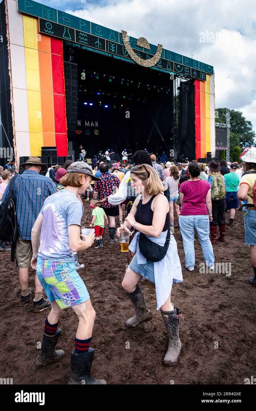 Un jeune couple dansant avec des bières dans la boue à la Mountain Stage au Green Man Festival, Brecon, pays de Galles, Royaume-Uni, 2023. Photo : Rob Watkins Banque D'Images