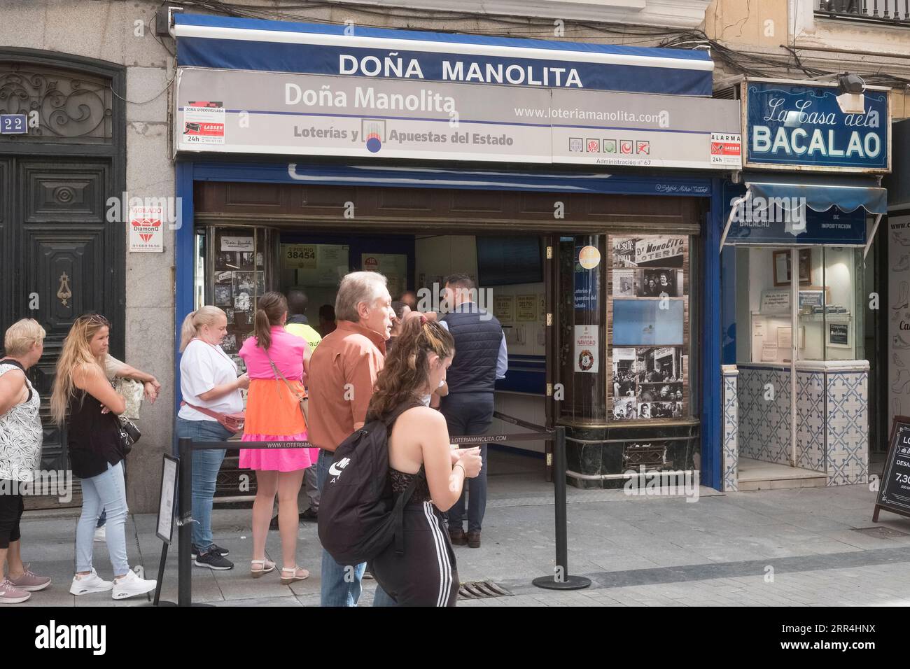 Une longue file d'attente devant le bureau de l'agence de loto Dona Manolita attendant d'acheter des billets pour la loterie espagnole de Noël, El Gordo, Madrid Espagne. Banque D'Images