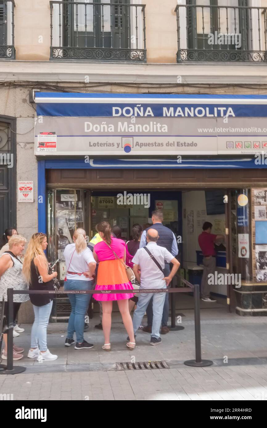 Une longue file d'attente devant le bureau de l'agence de loto Dona Manolita attendant d'acheter des billets pour la loterie espagnole de Noël, El Gordo, Madrid Espagne. Banque D'Images
