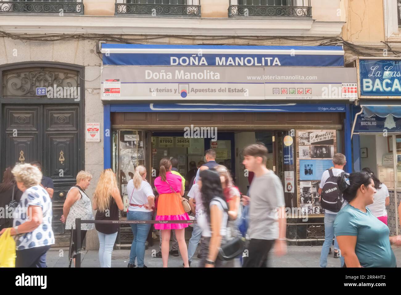 Une longue file d'attente devant le bureau de l'agence de loto Dona Manolita attendant d'acheter des billets pour la loterie espagnole de Noël, El Gordo, Madrid Espagne. Banque D'Images