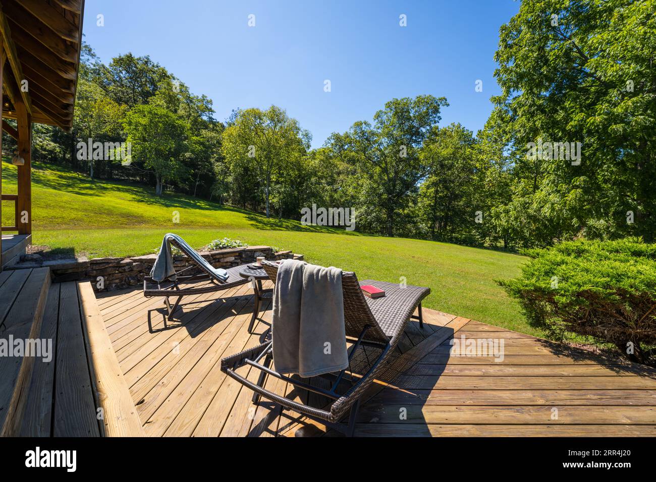 Un couple de chaises longues modernes sur une terrasse dans une maison de campagne. Banque D'Images