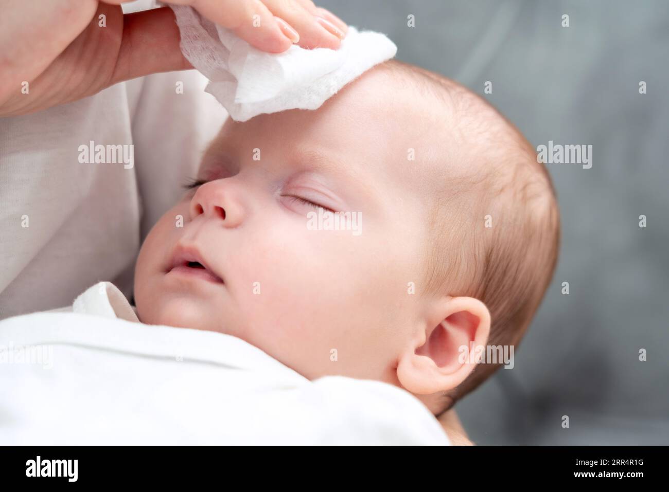 La lingette humide apporte un soulagement au nouveau-né, concept de l'instinct maternel pendant les problèmes de santé Banque D'Images