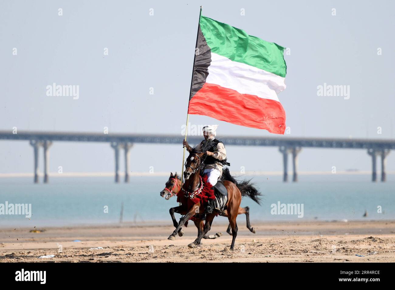 201212 -- GOVERNORATE DE JAHRA, 12 décembre 2020 -- Un homme tenant un drapeau koweïtien monte à cheval lors d'un spectacle équestre dans le gouvernorat de Jahra, Koweït, le 11 décembre 2020. Les propriétaires de chevaux arabes koweïtiens ont organisé un spectacle équestre vendredi dans le désert du gouvernorat de Jahra au Koweït pour présenter la tradition de l'équitation arabe. Photo de /Xinhua KUWAIT-JAHRA GOUVERNORAT-ARABIAN HORSE-RIDING SHOW GhazyxQaffaf PUBLICATIONxNOTxINxCHN Banque D'Images