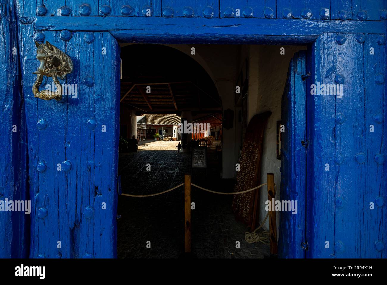 Portail en bois bleu avec la porte d'accès ouverte à une ancienne auberge Banque D'Images