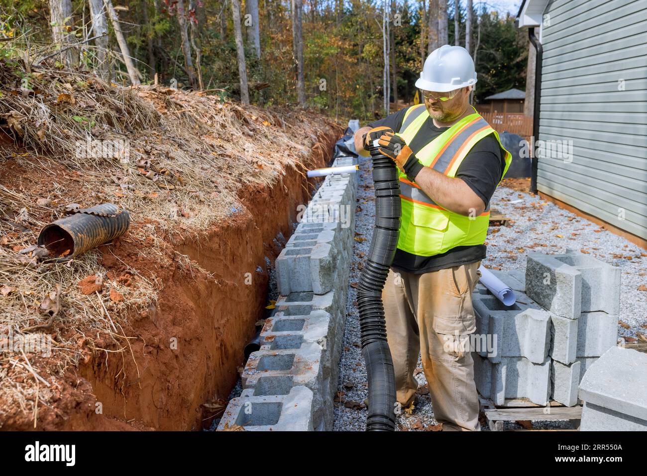 Travailleur de la construction de la pose de tuyau de drainage pour l — free download
