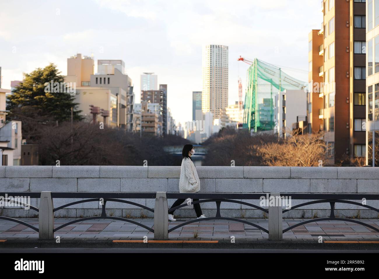 201231 -- TOKYO, le 31 décembre 2020 -- Une femme portant un masque facial traverse un pont à Tokyo, Japon, le 31 décembre 2020. Le nombre de nouveaux cas quotidiens de COVID-19 à Tokyo a dépassé la barre des 1 000 pour la première fois depuis l’apparition de la pandémie, a déclaré jeudi le gouverneur Yuriko Koike, avertissant que la troisième vague qui frappe la capitale est d’une taille sans précédent. JAPON-TOKYO-COVID-19-CAS DuxXiaoyi PUBLICATIONxNOTxINxCHN Banque D'Images