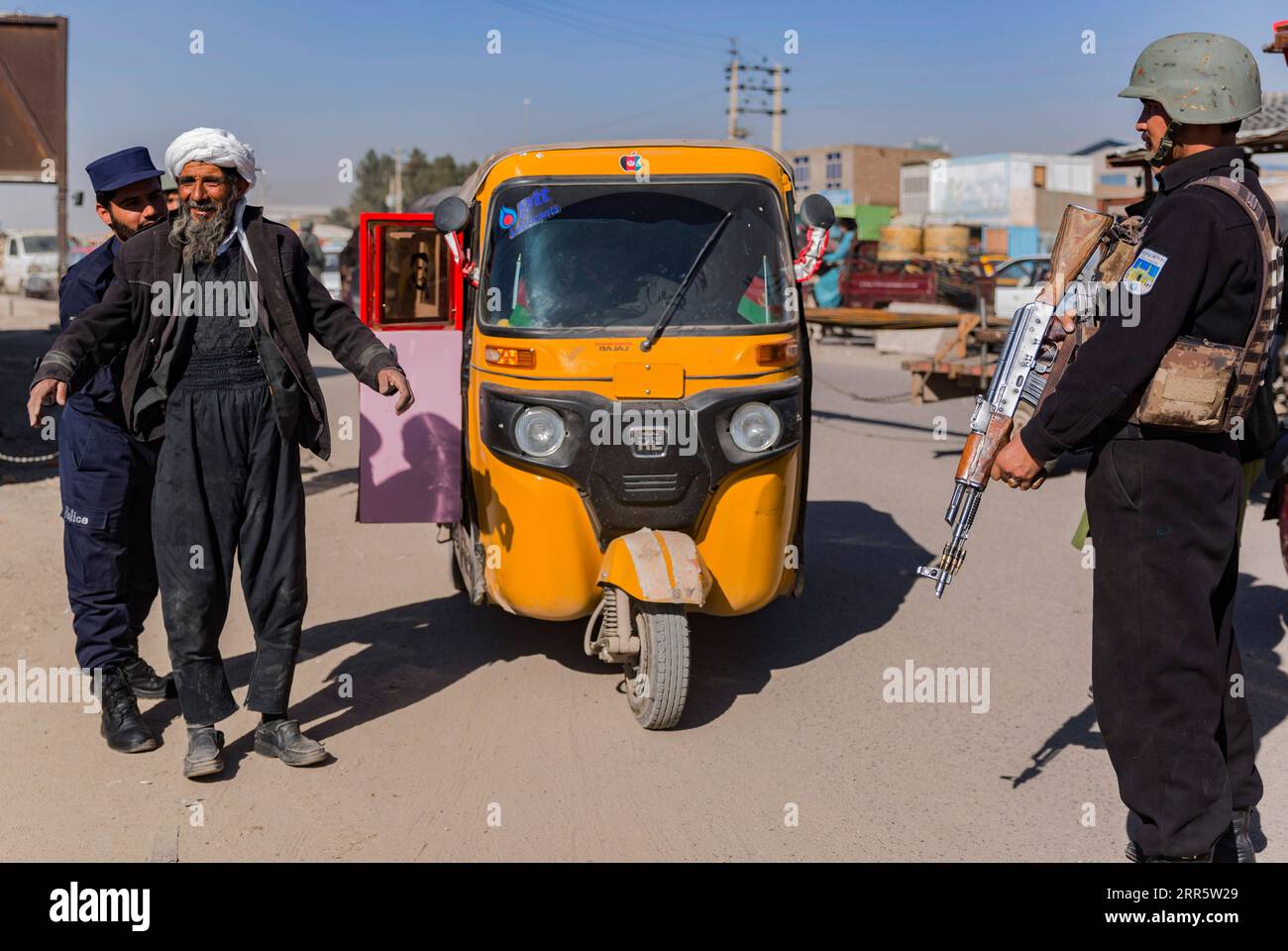 210116 -- HERAT, le 16 janvier 2021 -- Un policier fouille un homme à un point de contrôle de sécurité sur le chemin menant au district de Ghorian dans la province de Herat, Afghanistan, le 16 janvier 2021. Une attaque d'initiés a tué 12 miliciens pro-gouvernementaux dans le district de Ghorian, dans la province occidentale de Herat, vendredi soir, a déclaré samedi le porte-parole de la police provinciale Abdul Ahad Walizada. Selon le responsable, deux infiltrés talibans présumés de la milice pro-gouvernementale ont ouvert le feu sur d'autres miliciens dans le district de Ghorian de la province de Herat vendredi alors qu'ils prenaient le dîner, tuant 12 sur place et s'échappant avec eux Banque D'Images