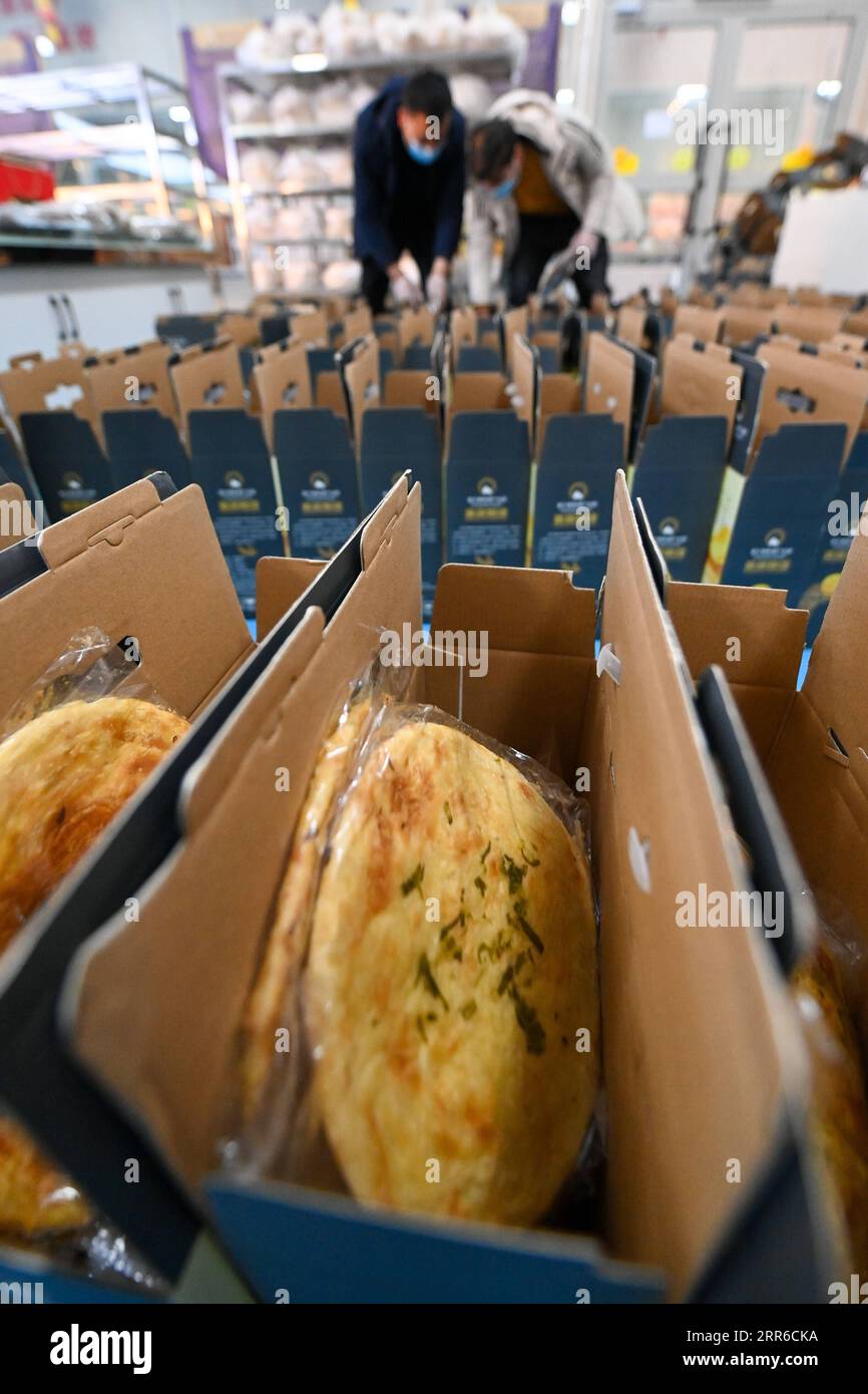 210206 -- HORGOS , le 6 février 2021 -- des travailleurs emballent Nang, un pain plat local, dans un parc industriel à Horgos, dans la région autonome ouïgoure du Xinjiang du nord-ouest de la Chine, le 5 février 2021. Depuis 2020, les autorités locales construisent un parc industriel de fabrication de Nang avec production et vente de nourriture. Jusqu'à présent, le parc a atteint un équilibre quotidien entre l'offre et la demande, avec un volume total de ventes de plus de 8 millions en dehors du Xinjiang. Plus de 2 000 000 personnes se voient offrir des possibilités d'emploi avec des revenus accrus. CHINE-XINJIANG-HORGOS-NANG-MARCHÉ CN DINGXLEI PUBLICATIONXNOTXINXCHN Banque D'Images