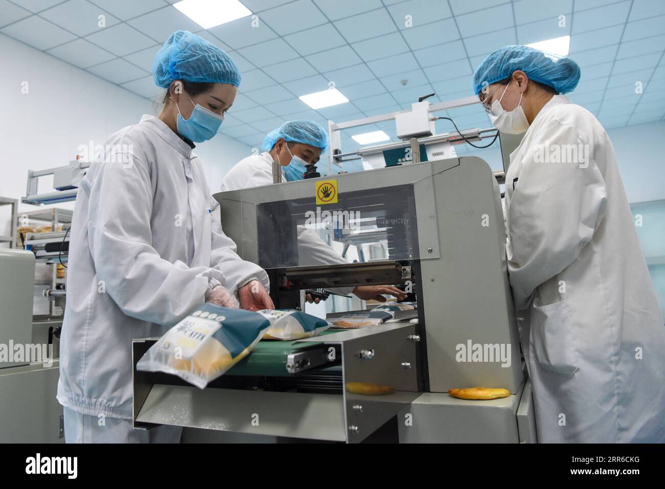 210206 -- HORGOS , le 6 février 2021 -- des travailleurs sont vus à l'atelier d'emballage d'un parc industriel à Horgos, dans la région autonome ouïgoure du Xinjiang, au nord-ouest de la Chine, le 5 février 2021. Depuis 2020, les autorités locales construisent un parc industriel de fabrication de Nang avec production et vente de nourriture. Jusqu'à présent, le parc a atteint un équilibre quotidien entre l'offre et la demande, avec un volume total de ventes de plus de 8 millions en dehors du Xinjiang. Plus de 2 000 000 personnes se voient offrir des possibilités d'emploi avec des revenus accrus. CHINE-XINJIANG-HORGOS-NANG-MARCHÉ CN DINGXLEI PUBLICATIONXNOTXINXCHN Banque D'Images