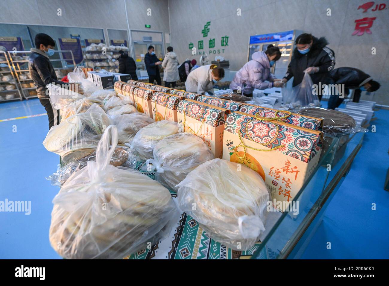 210206 -- HORGOS , le 6 février 2021 -- des travailleurs emballent Nang, un pain plat local, dans un parc industriel à Horgos, dans la région autonome ouïgoure du Xinjiang du nord-ouest de la Chine, le 5 février 2021. Depuis 2020, les autorités locales construisent un parc industriel de fabrication de Nang avec production et vente de nourriture. Jusqu'à présent, le parc a atteint un équilibre quotidien entre l'offre et la demande, avec un volume total de ventes de plus de 8 millions en dehors du Xinjiang. Plus de 2 000 000 personnes se voient offrir des possibilités d'emploi avec des revenus accrus. CHINE-XINJIANG-HORGOS-NANG-MARCHÉ CN DINGXLEI PUBLICATIONXNOTXINXCHN Banque D'Images