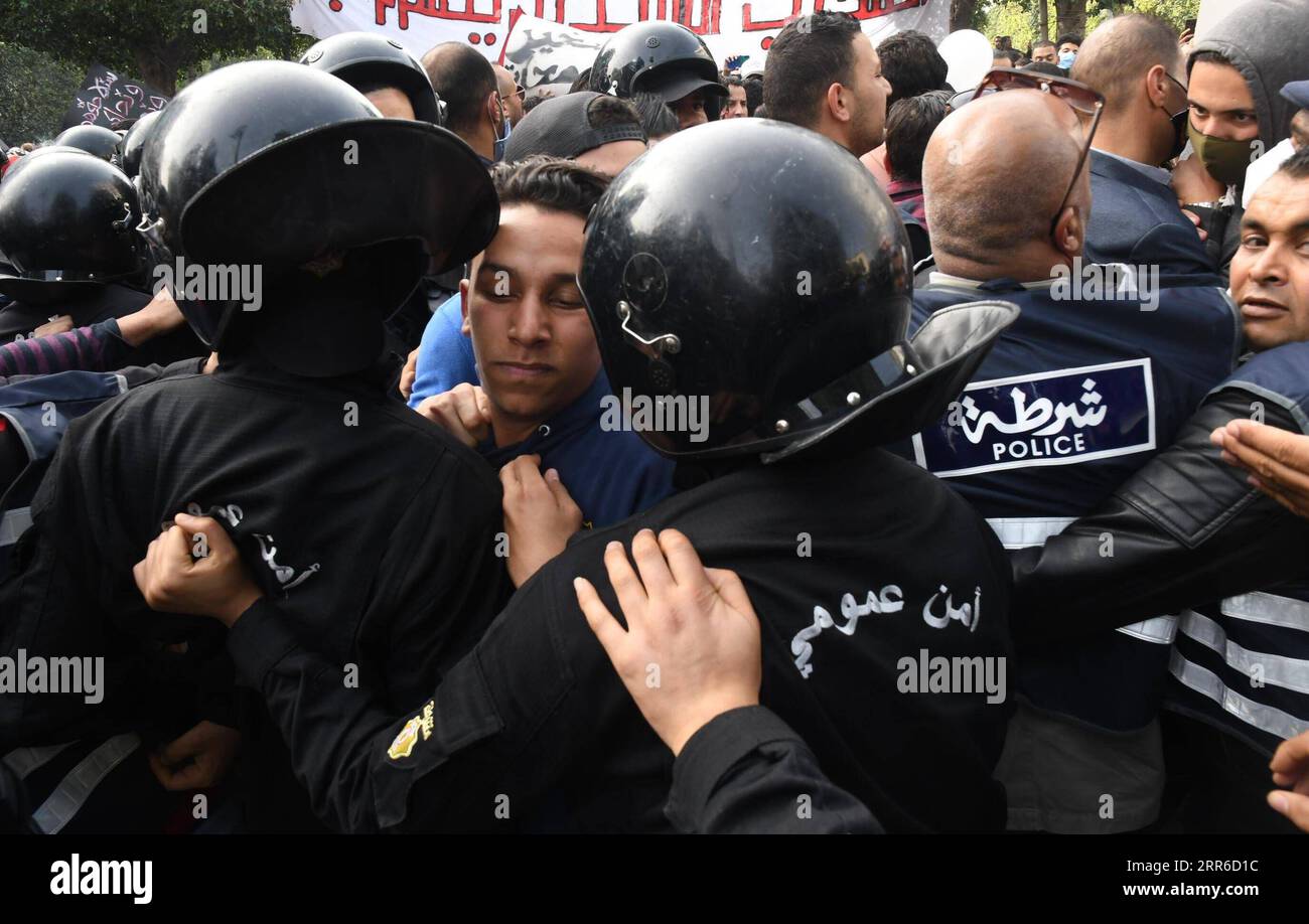 210206 -- TUNIS, le 6 février 2021 -- des policiers affrontent des manifestants lors d'une manifestation à Tunis, Tunisie, le 6 février 2021. Une marche de protestation a été organisée samedi dans la capitale tunisienne Tunis pour commémorer le huitième anniversaire de l'assassinat de l'opposant de gauche Chokri Belaid dans le cadre de mesures de sécurité strictes. Photo de /Xinhua TUNISIA-TUNIS-PROTEST AdelxEzzine PUBLICATIONxNOTxINxCHN Banque D'Images