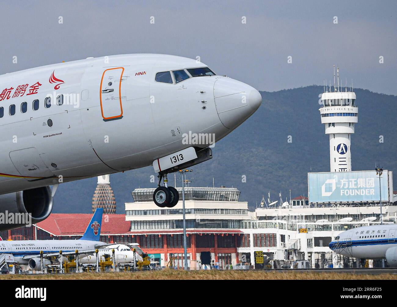 210211 -- SANYA, le 11 février 2021 -- Un avion décolle avec la tour de contrôle du trafic aérien de Sanya en arrière-plan à l'aéroport international de Sanya Phoenix à Sanya, dans la province de Hainan du sud de la Chine, le 28 janvier 2021. Hong Yuan, 29 ans, est contrôleur de la circulation aérienne à la tour de contrôle de la circulation aérienne de Sanya. En tant que contrôleur de la circulation aérienne, Hong est responsable de la navigation aérienne, de guider les pilotes pendant le décollage et l'atterrissage, et de surveiller les avions lorsqu'ils voyagent dans le ciel. Ce travail exige une grande attention. Les membres du personnel sont donc censés prendre une pause toutes les deux heures pour se remettre du Banque D'Images