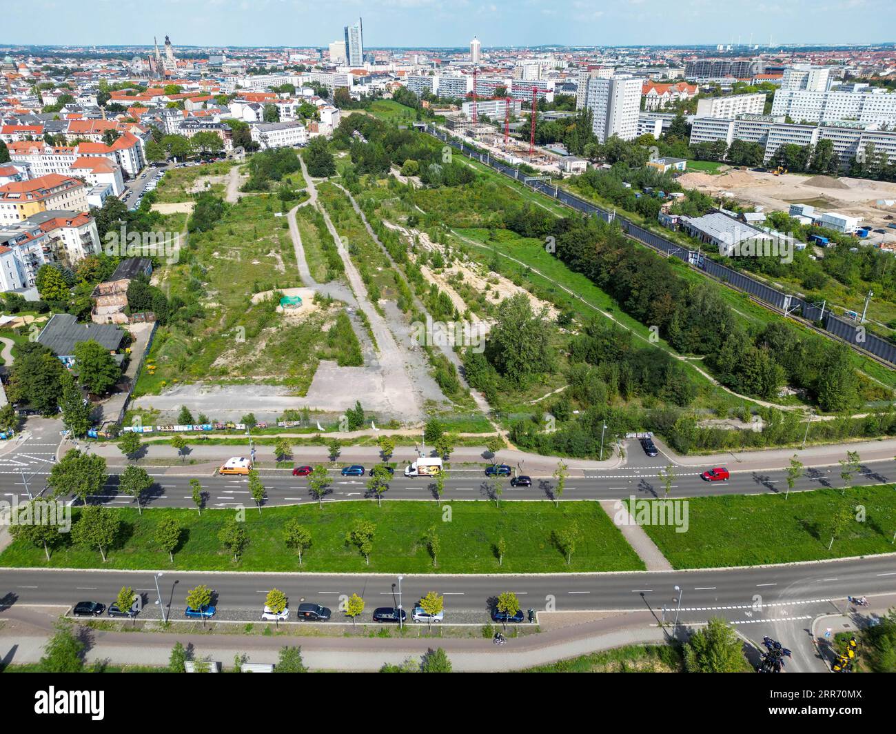 23 août 2023, Saxe, Leipzig : vue de l'espace ouvert non aménagé derrière la gare Bayerischer Bahnhof au sud de Leipzig, avec le pont Semmelweißbrücke sur Kurt-Eisner-Strasse au premier plan. Avec le plan de développement n° 397,1 'Urban Space Bayerischer Bahnhof - Urban Quarter Lößniger Straße', un nouveau quartier doit être créé sur la friche de 36 hectares. Un parc de huit hectares, environ 1 800 appartements, écoles, salles de sport, garderies, des magasins et environ 150 000 mètres carrés d'espace commercial sont prévus dans le quartier des deux côtés de la route du tunnel de la ville. (Antenne Banque D'Images