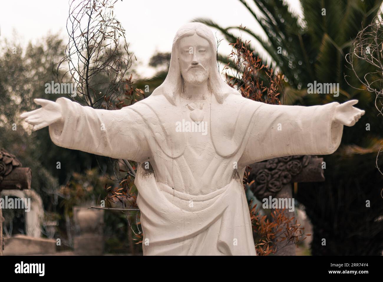 statue religieuse blanche figure du christ ouvrant ses bras dans un cimetière extérieur Banque D'Images