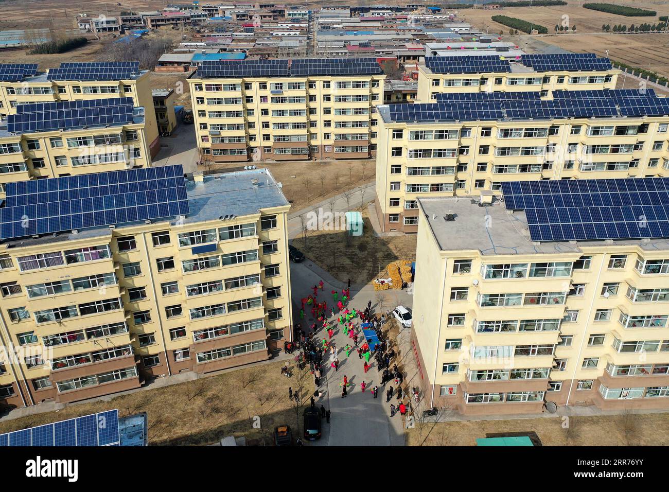 210316 -- TAIYUAN, le 16 mars 2021 -- une photo aérienne prise le 9 mars 2021 montre des villageois jouant de la danse yangge dans un complexe résidentiel pour les villageois réinstallés dans la ville de Yukou du comté de Fangshan, province du Shanxi, dans le nord de la Chine. Shijiamao est un petit village situé dans des zones montagneuses accidentées avec peu de précipitations. Comme d’autres villageois ici, Liu Qingji, un agriculteur de 85 ans, pratiquait l’agriculture à la merci des éléments. Ayant habité de nombreuses années dans un sombre yaodong, une maison construite dans la terre durcie commune à travers le plateau de Loess dans le nord de la Chine, Liu espérait améliorer les conditions de vie Banque D'Images