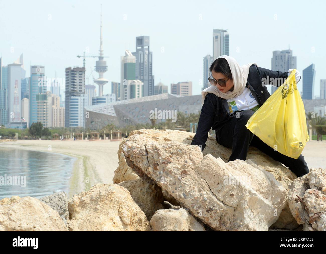 210323 -- KUWAIT CITY, le 23 mars 2021 -- Une femme participe à une campagne de nettoyage de plage à Kuwait City, Koweït, le 23 mars 2021. Photo par /Xinhua KOWEÏT-KOWEÏT VILLE-NETTOYAGE DE LA PLAGE Asad PUBLICATIONxNOTxINxCHN Banque D'Images