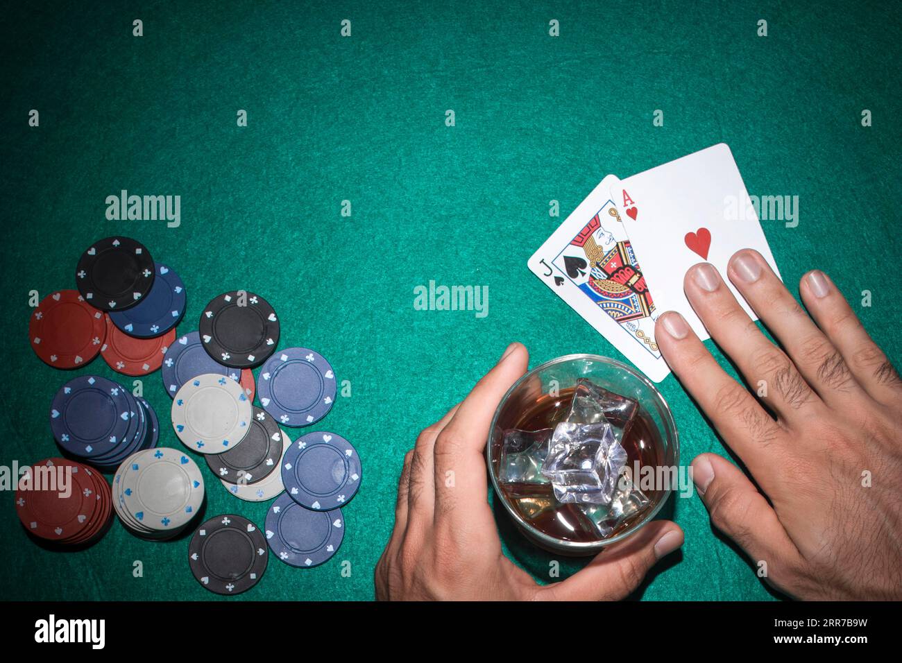 Joueur de poker montrant la carte as de Jack avec des jetons de casino vert table de poker Banque D'Images