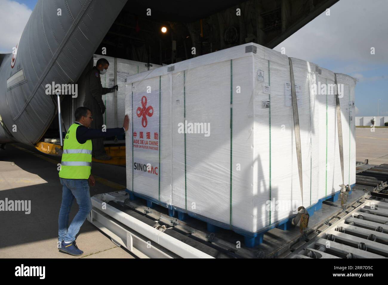 210326 -- TUNIS, le 26 mars 2021 -- les travailleurs de l'aéroport déchargent le vaccin contre le COVID-19 aidé par la Chine à l'aéroport international de Carthage à Tunis, Tunisie, le 25 mars 2021. La Tunisie a reçu jeudi un lot de vaccin COVID-19 donné par la Chine et livré à bord d’un avion militaire du ministère tunisien de la Défense. Photo de /Xinhua TUNISIE-TUNIS-COVID-19 VACCIN-CHINE AdelxEzzine PUBLICATIONxNOTxINxCHN Banque D'Images