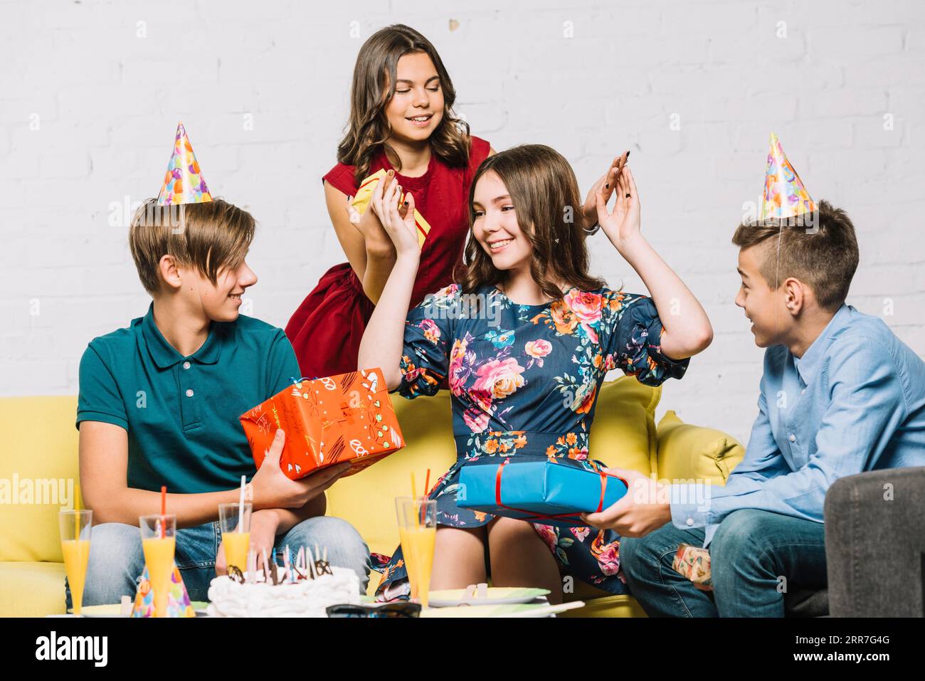 Joyeux anniversaire fille regardant ses amis tenant des boîtes cadeaux Banque D'Images