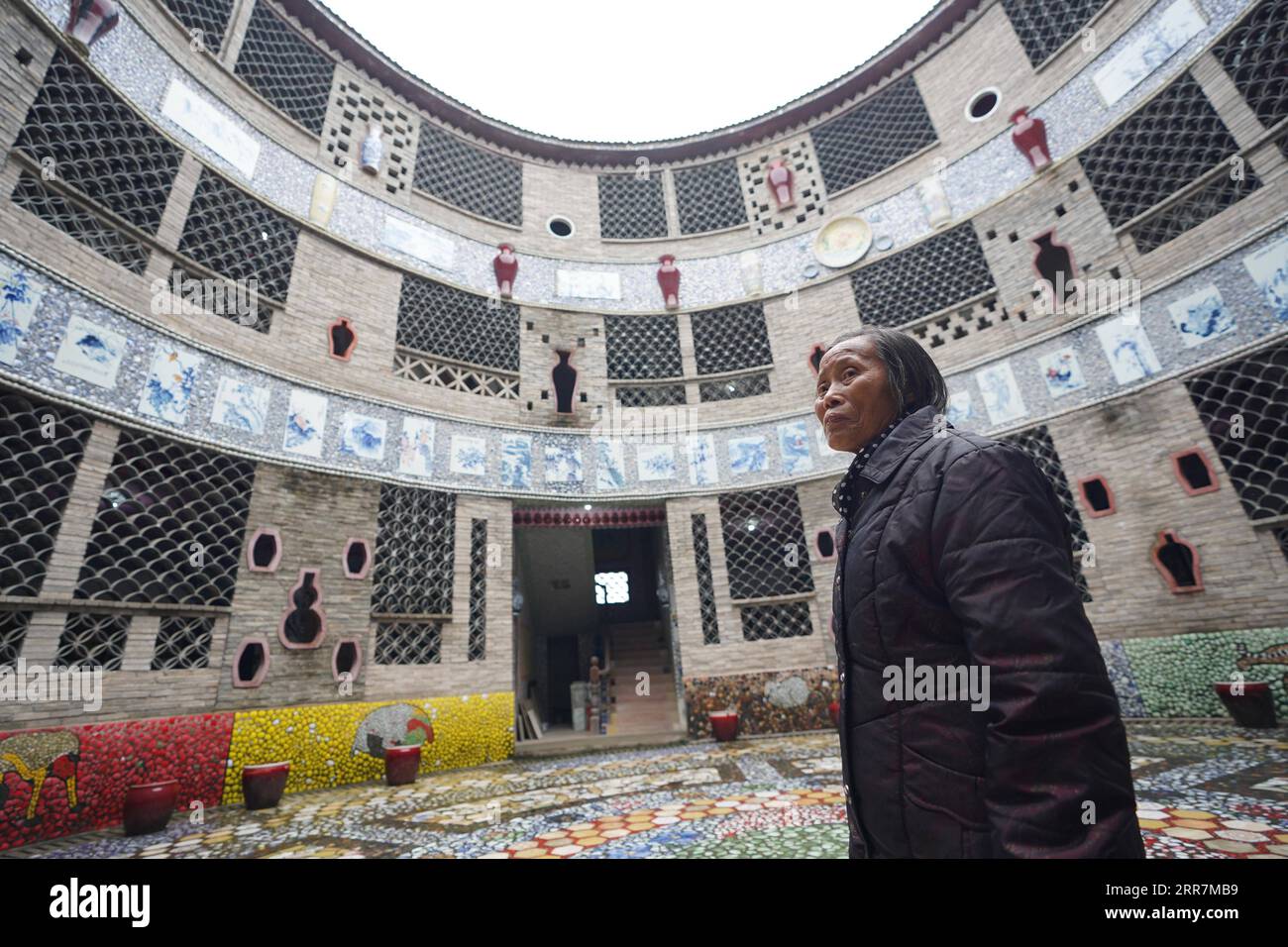210331 -- NANCHANG, le 31 mars 2021 -- Yu Ermei présente son palais de porcelaine aux visiteurs du village de Xinping du comté de Fuliang à Jingdezhen, dans la province de Jiangxi dans l'est de la Chine, le 19 mars 2021. Yu Ermei, une villageoise de 91 ans qui travaillait autrefois dans une manufacture de porcelaine, a commencé à construire ses palais de porcelaine dans le village de Xinping à partir de 2011. Grâce à ses efforts, quatre bâtiments décorés de porcelaine et de pièces de porcelaine se dressent maintenant dans le village, attirant de nombreux touristes à visiter. CHINE-JIANGXI-JINGDEZHEN-PORCELAINE PALACESCN ZhouxMi PUBLICATIONxNOTxINxCHN Banque D'Images