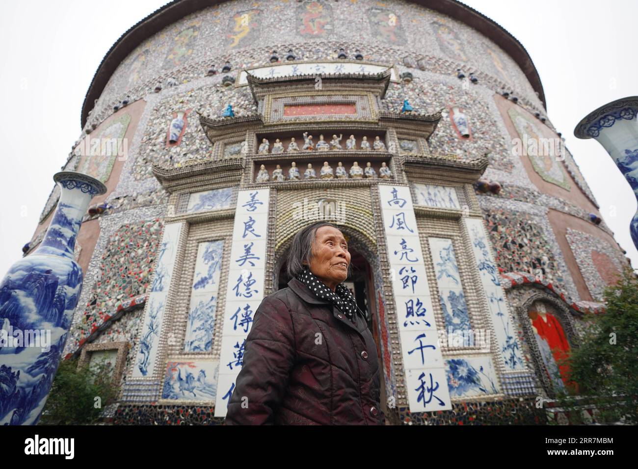 210331 -- NANCHANG, le 31 mars 2021 -- Yu Ermei présente son palais de porcelaine aux visiteurs du village de Xinping du comté de Fuliang à Jingdezhen, dans la province de Jiangxi dans l'est de la Chine, le 19 mars 2021. Yu Ermei, une villageoise de 91 ans qui travaillait autrefois dans une manufacture de porcelaine, a commencé à construire ses palais de porcelaine dans le village de Xinping à partir de 2011. Grâce à ses efforts, quatre bâtiments décorés de porcelaine et de pièces de porcelaine se dressent maintenant dans le village, attirant de nombreux touristes à visiter. CHINE-JIANGXI-JINGDEZHEN-PORCELAINE PALACESCN ZhouxMi PUBLICATIONxNOTxINxCHN Banque D'Images